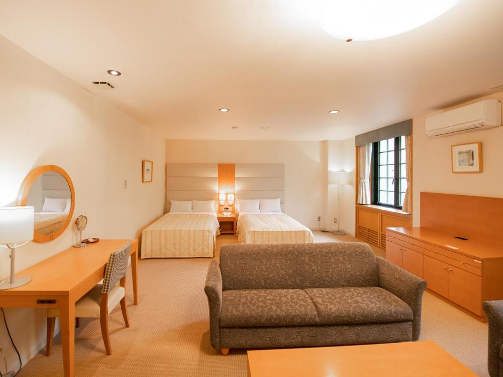 Postel nebo postele na pokoji v ubytování Tabist Hotel Colosseum Inn Tateshina
