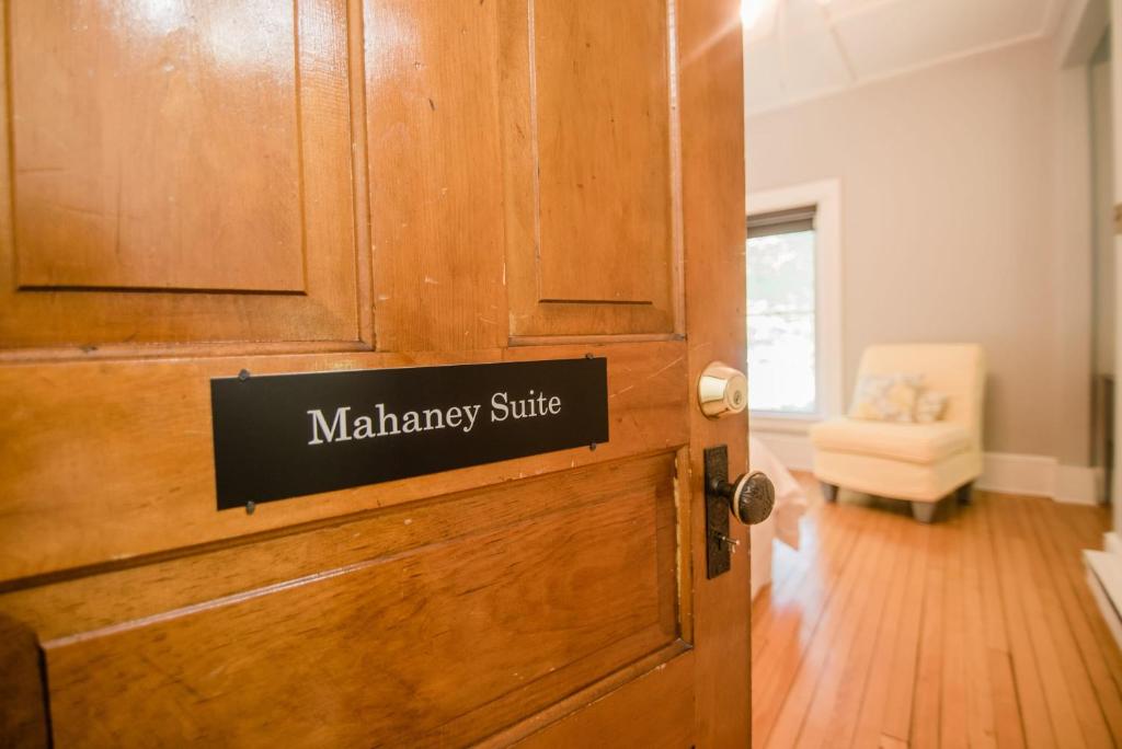 a wooden door with a sign on it at Mahaney Suite BW Boutique Hotel in Central Lake