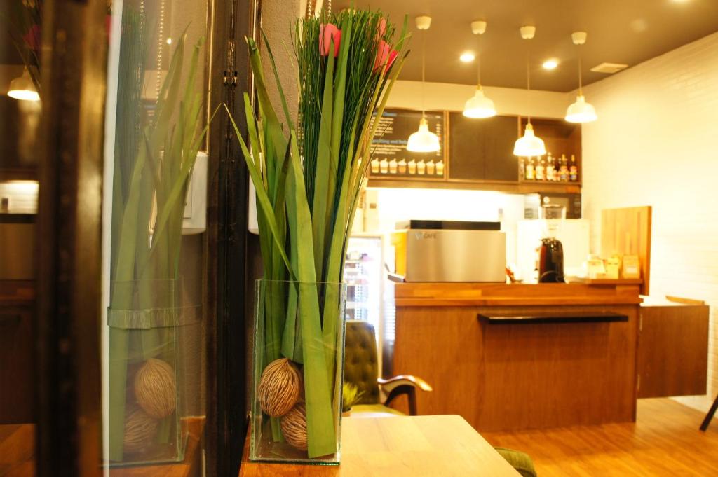 A warmly lit counter area with a tall floral arrangement and displayed drinks.