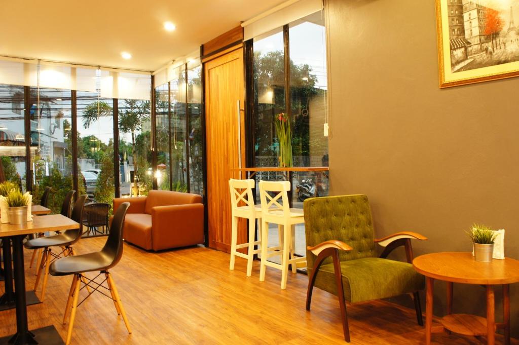 A warmly lit restaurant lounge with tables, chairs and window-side seating.