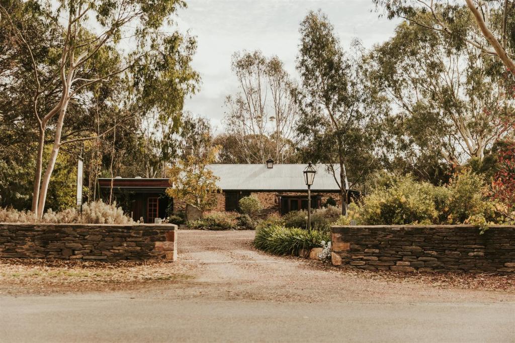 una casa con una pared de piedra y un camino de entrada en Mintaro Cottage, en Mintaro