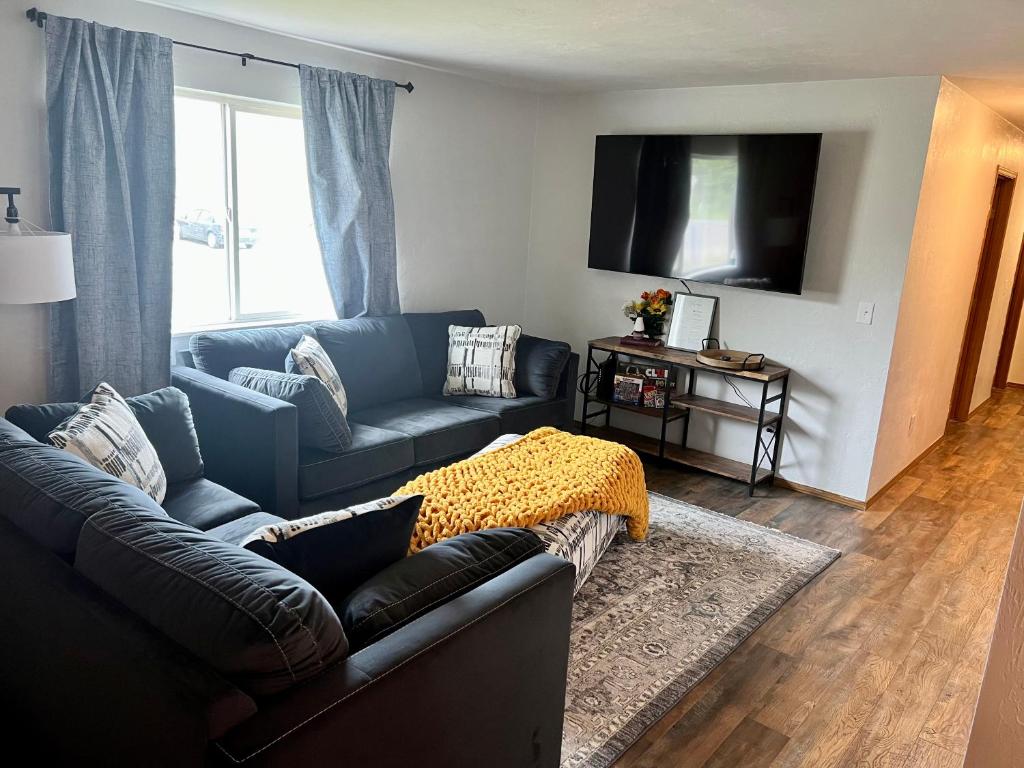 ein Wohnzimmer mit einem Sofa und einem TV in der Unterkunft The Perfect 3 Bedroom Apartment - Central location in Fairbanks