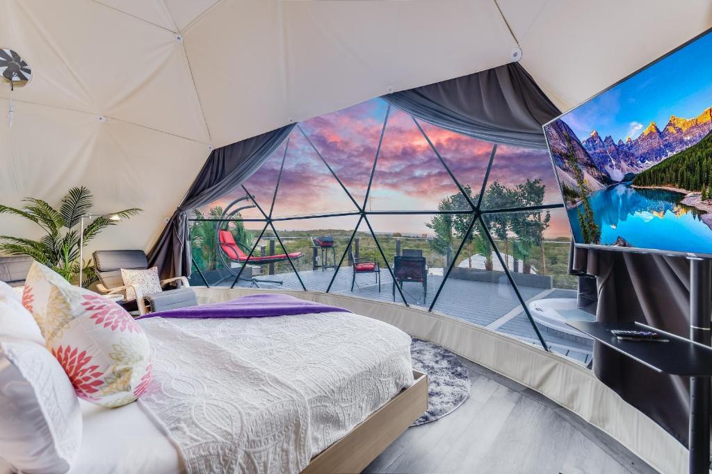 a room with a bed and a large window at Udoscape Glamping Resort in Lago Vista