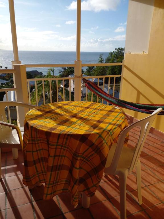 uma mesa e cadeiras numa varanda com o oceano em Studio Tartane avec vue sur mer em La Trinité
