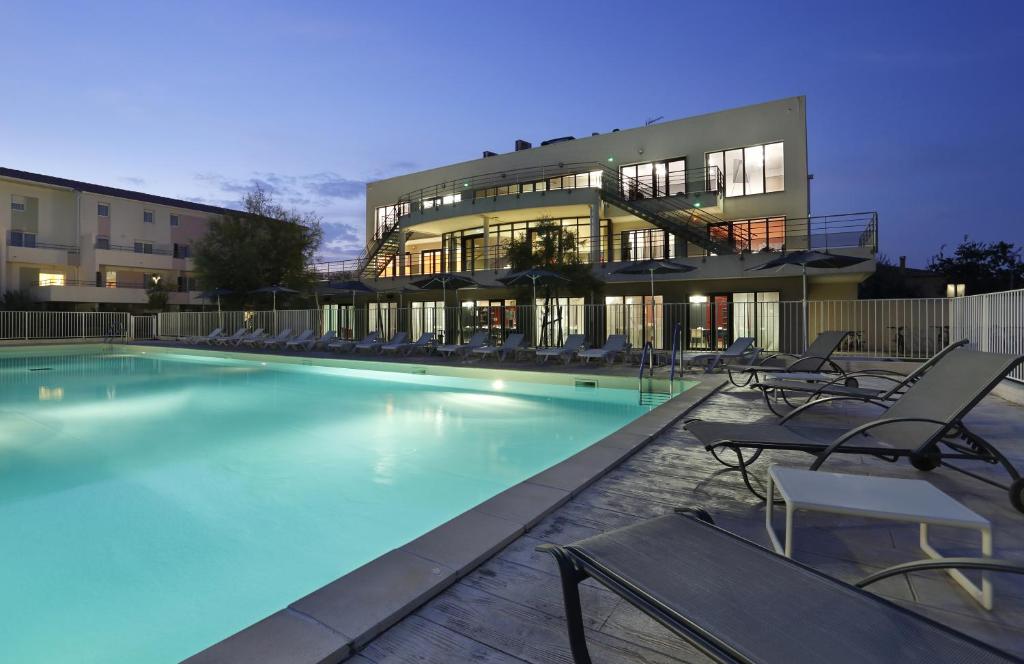 une grande piscine en face d'un bâtiment dans l'établissement Vacancéole - Résidence Cap Camargue, au Grau-du-Roi