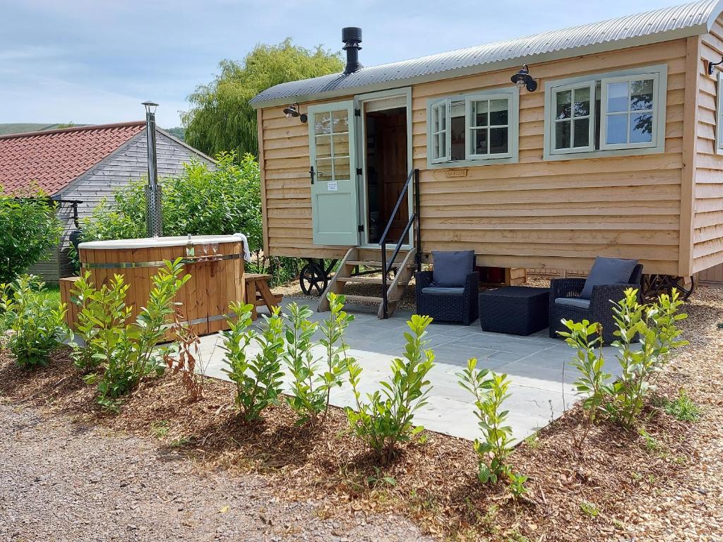 een tiny house met blauwe stoelen op een patio bij Acorn in Weston-super-Mare