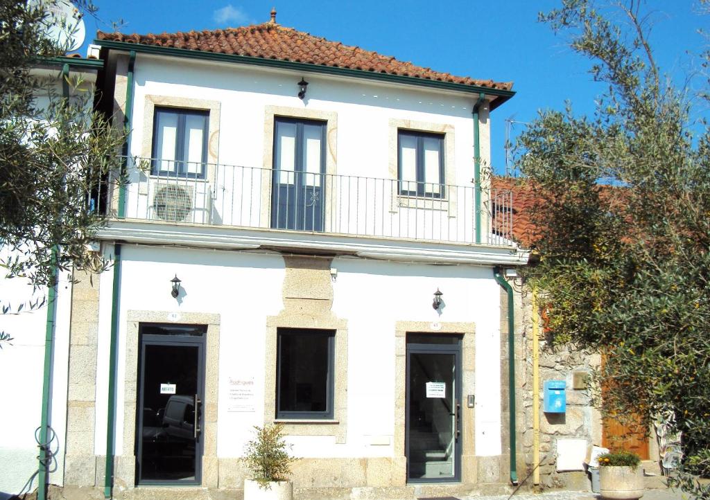 Casa blanca antigua con balcón en una calle en Casa do Mosteiro de Refoios do Lima, en Ponte de Lima