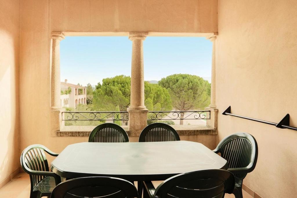 une table et des chaises dans une pièce avec une fenêtre dans l'établissement Village Pont Royal en Provence - maeva Home - Appartement 2 Pièces 7 Personnes Confort MAE-2253, à Mallemort