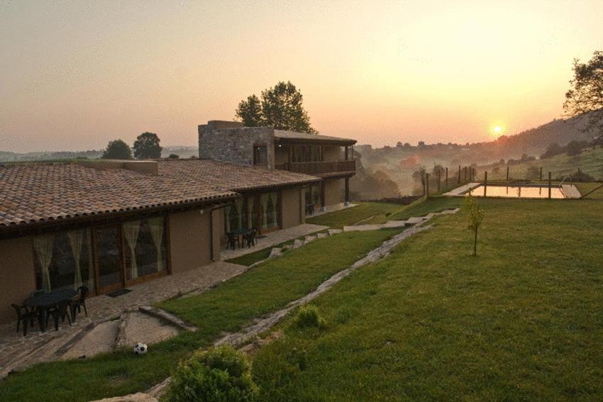 a house in a field with the sunset in the background at Alcabala del Viento in Noriega