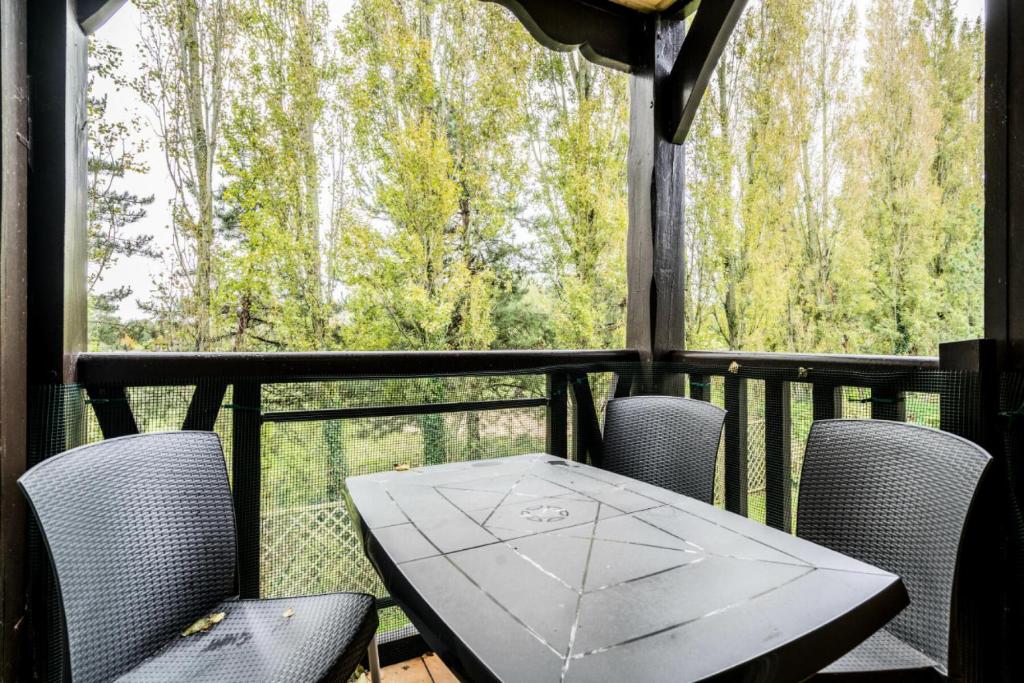 a table and chairs on a balcony with a view of trees at La Résidence du Golf - maeva Home - Appartement 2 pièces 4 personnes - Conf 48 in Deauville