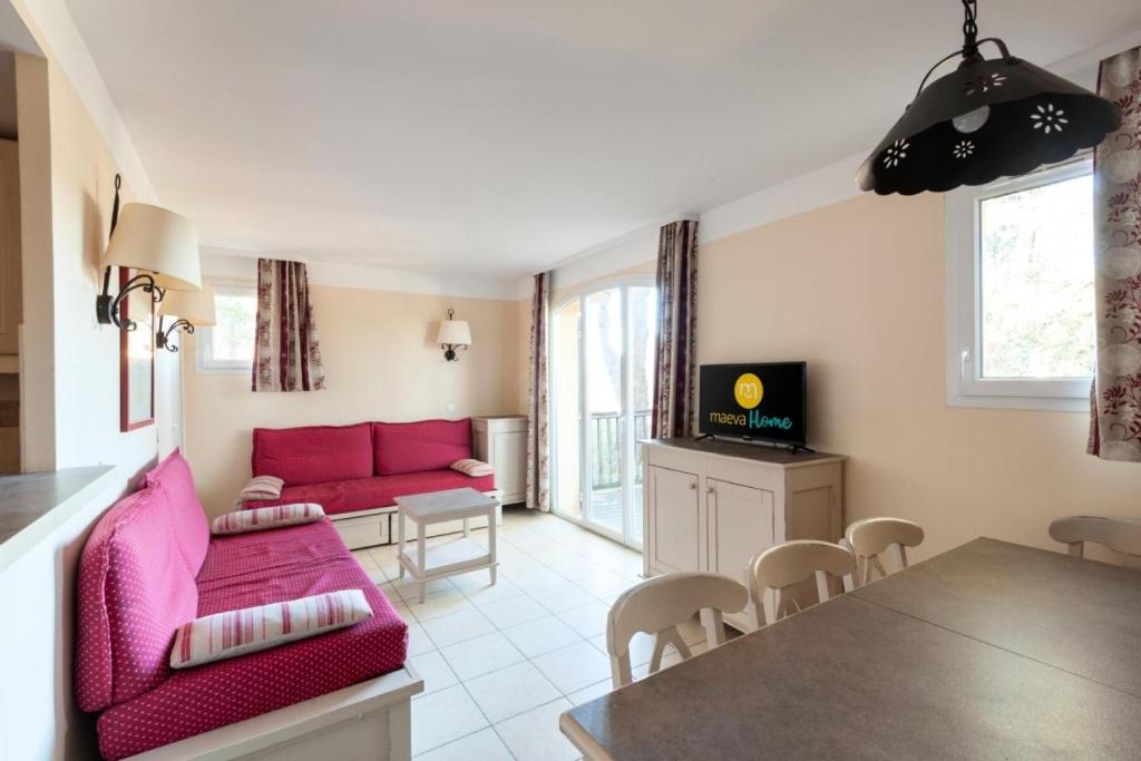 un salon avec un canapé rose et une table dans l'établissement Les Coteaux de Pont Royal en Provence - maeva Home - Maison 4 Pièces 8 Personnes - Budget MAE-6009, à Mallemort
