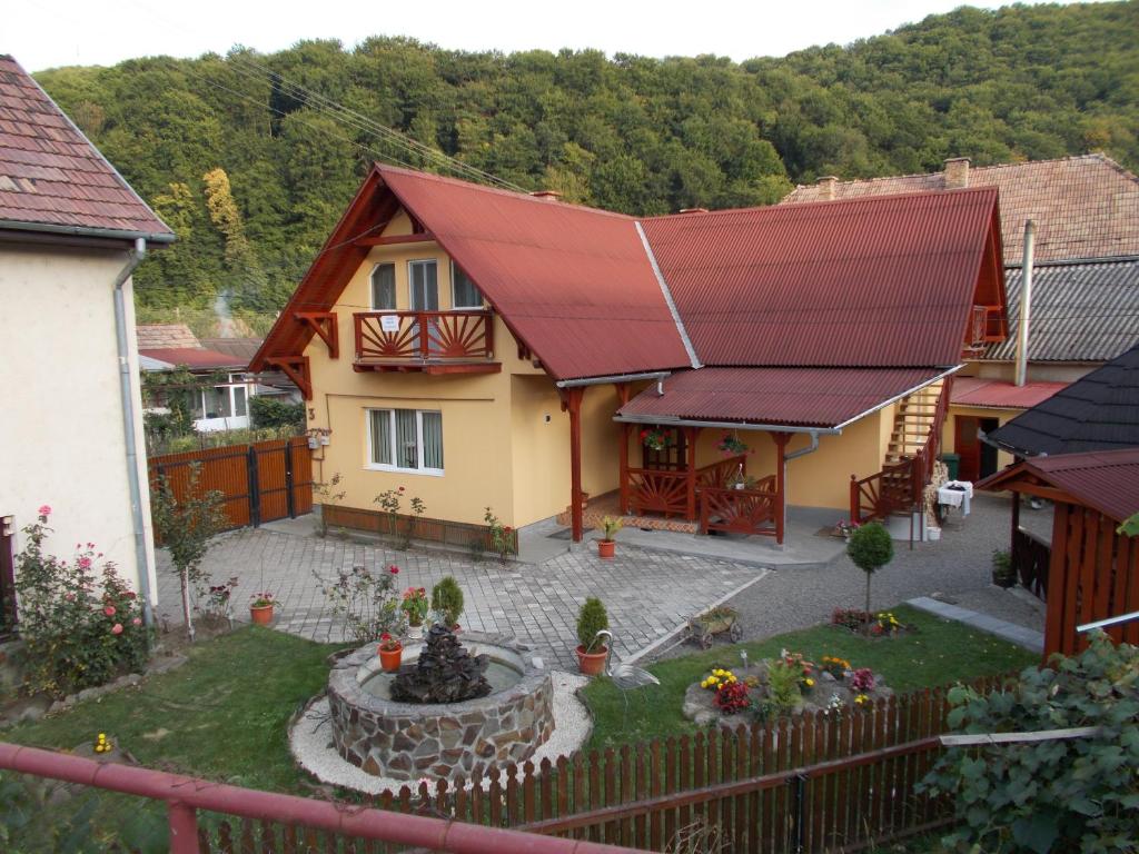una casa con techo rojo y fuente en Napsugár Vendégház en Sovata