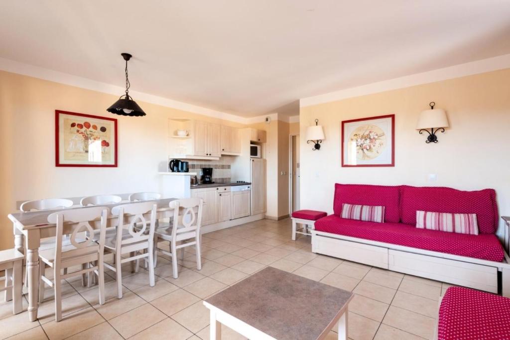 Il comprend un salon avec un canapé rouge et une cuisine. dans l'établissement Les Coteaux de Pont Royal en Provence - maeva Home - Appartement 3 Pièces 6 81, à Mallemort