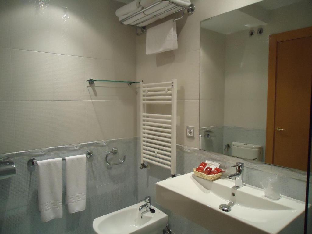 un baño con lavabo y espejo en Hotel Parrilla el Zangano, en Boal
