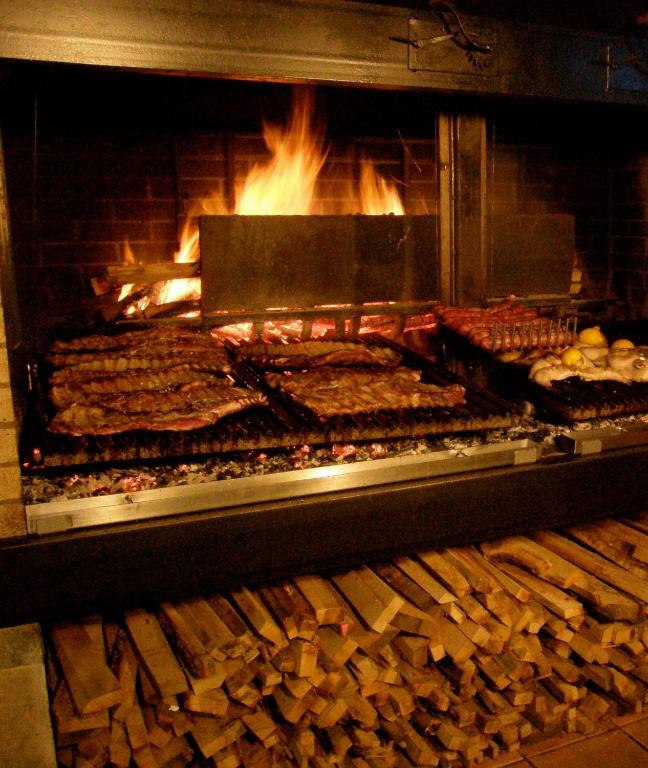 una parrilla con muchos tipos diferentes de comida. en Hotel Parrilla el Zangano, en Boal