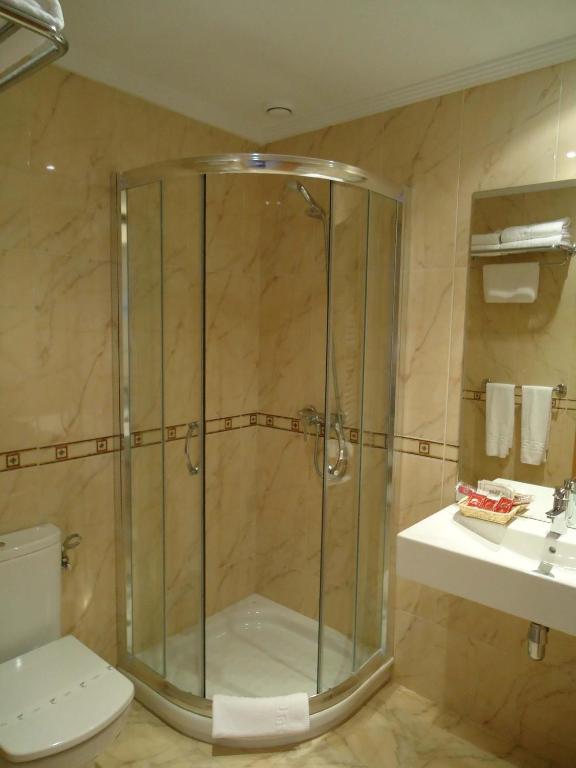 Un baño con ducha, inodoro y lavabo. en Hotel Parrilla el Zangano, en Boal