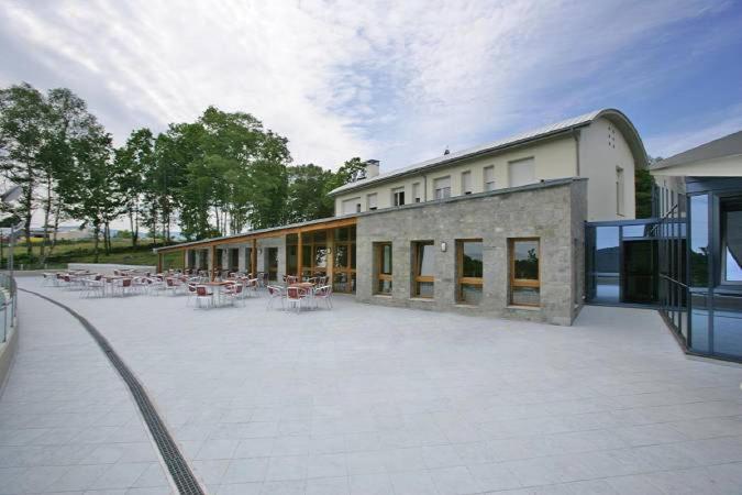 a large patio with tables and chairs in front of a building at Hotel Parrilla el Zangano in Boal