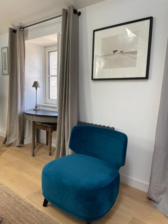 a blue chair in a living room with a table at Kermaria Studio Suite in Pont-Aven