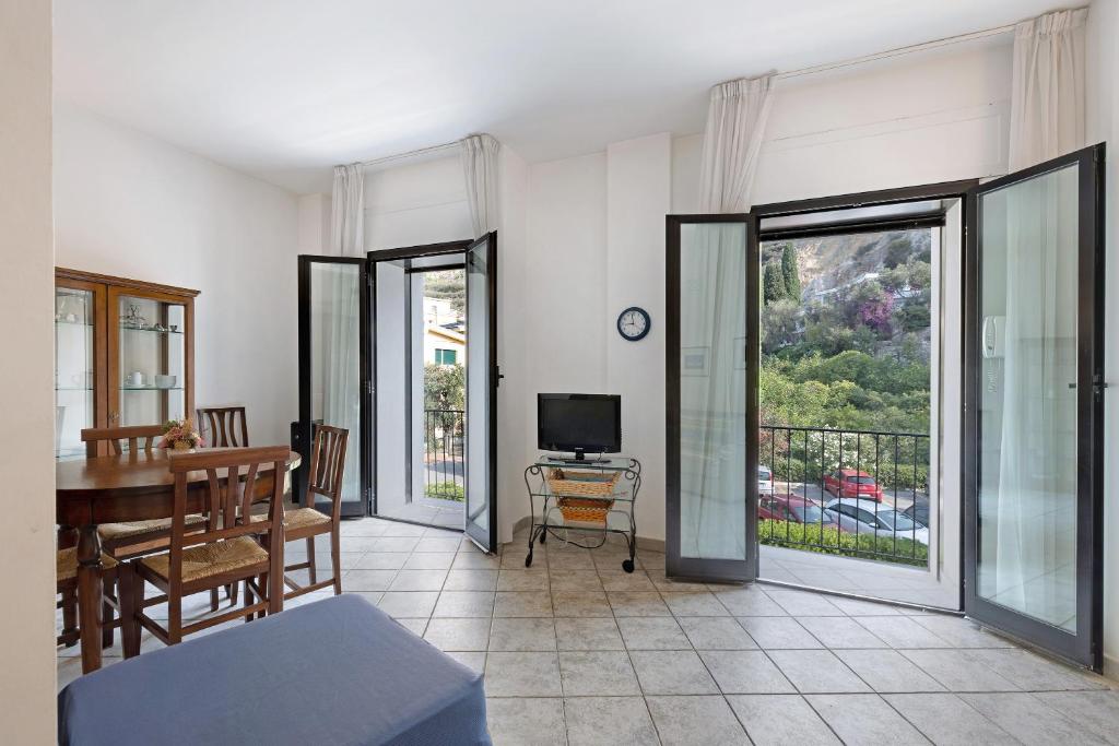 a living room with a table and a television and sliding glass doors at 13 Mehari in Varigotti
