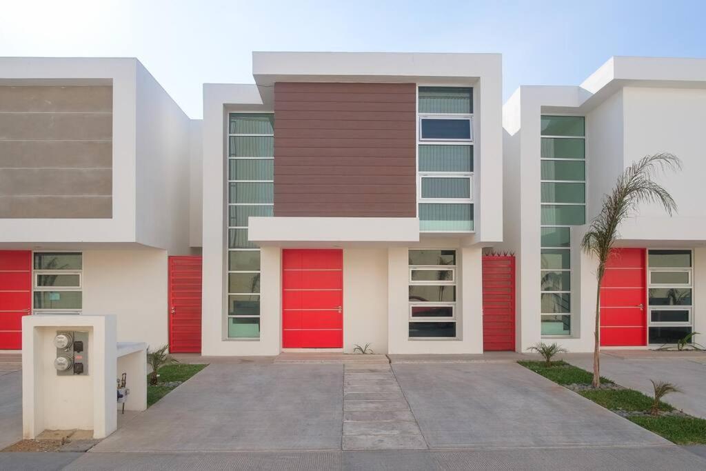 New House / VIP / 1 Block to the Beach في إنسينادا: مبنى بأبواب حمراء على جانبه
