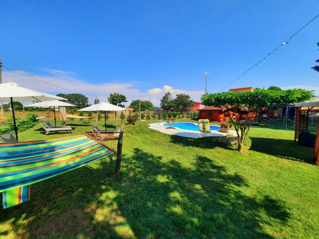 podwórze z basenem z parasolami i krzesłami oraz dziedzińcem w obiekcie Residence Il Tiglio w mieście Spilinga