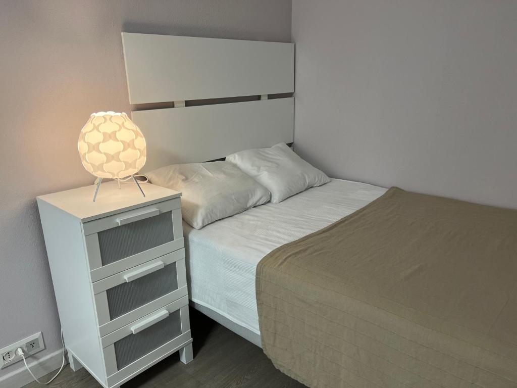 a bedroom with a bed and a lamp on a night stand at Forest apartments in Kouvola