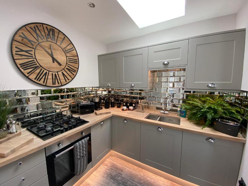 a kitchen with a large clock on the wall at The Bolthole in Margate