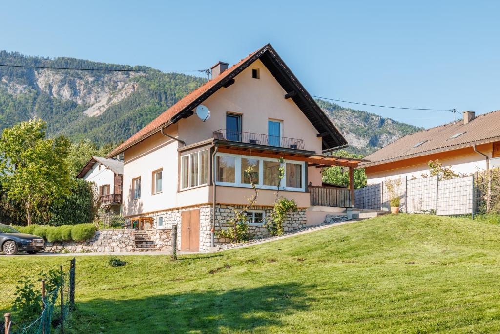 a house on a hill with a green yard at Ferienhaus Auszeit Natur in Villach