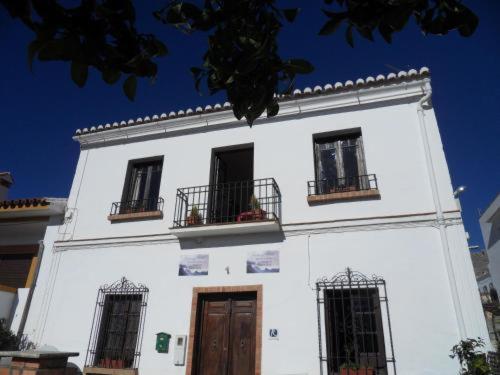 un edificio blanco con tres ventanas y una puerta en El Rincon del Torcal en Villanueva de la Concepción