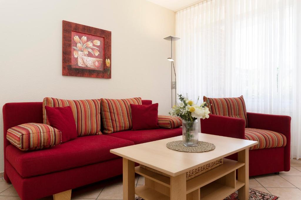 a living room with a red couch and a table at Sonnenwinkel Wohnung 2 in Kellenhusen