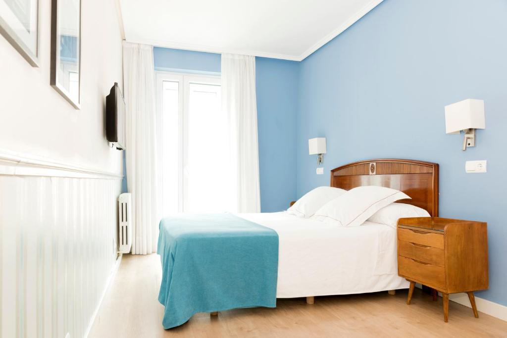 サラゴサにあるホテル ソースのベッドルーム1室(白いベッド1台、青い壁付)
