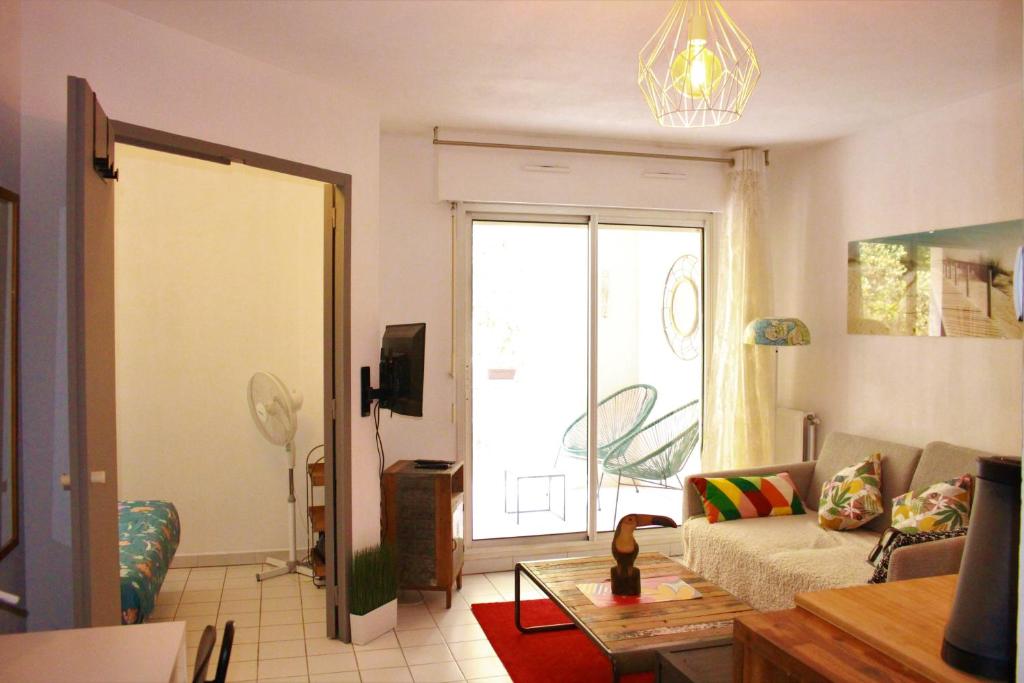 een woonkamer met een bank en een raam bij Appartement cozy aux Beaux Arts - Casa La Selva in Montpellier