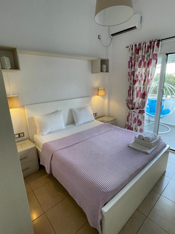 a bedroom with a large bed with a pink blanket at Hotel Mira Mare in Ksamil