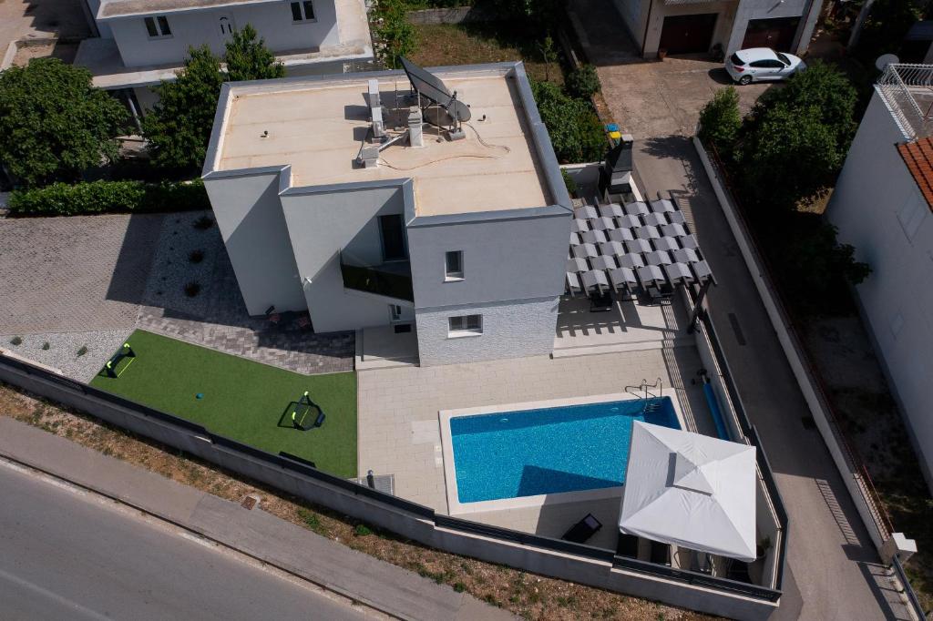 an aerial view of a house with a swimming pool at Villa Lumaka Sun - Amazing Home In Brodarica with 4 Bedrooms, Wifi, Outdoor Swimming Pool and Heated Swimming Pool in Brodarica