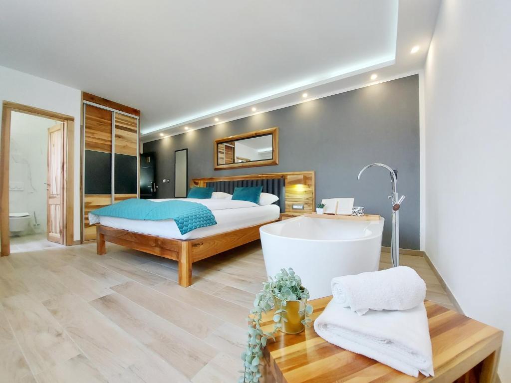 a bedroom with a bed and a tub in a room at Etno Boutique in Plitvička Jezera