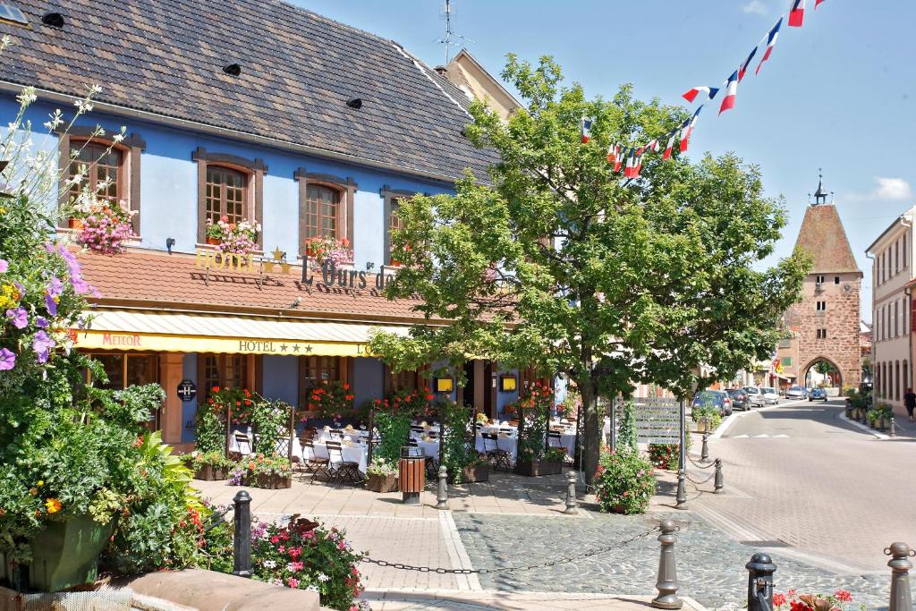 a street in a town with a blue building at Hôtel L'Ours De Mutzig in Mutzig