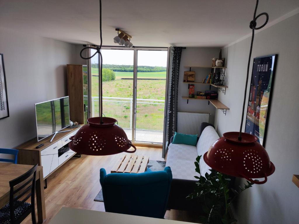 uma sala de estar com um sofá e uma grande janela em Przytulne i Komfortowe Mieszkanie Nad Morzem em Pogórze