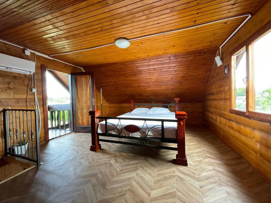 ein Schlafzimmer mit einem Bett in einem Holzzimmer in der Unterkunft Wooden House in Podgorica