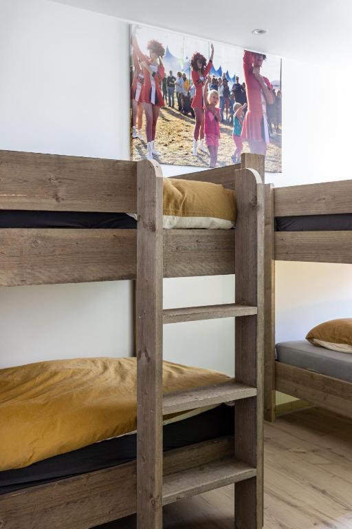 two bunk beds in a room with a picture on the wall at Vakantieverblijf De Backstage in Heuvelland