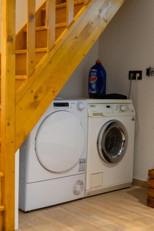a washing machine in a laundry room with a ladder at Vakantieverblijf De Backstage in Heuvelland