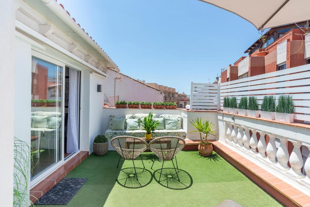 un balcón con 2 sillas y una mesa. en Fantastic Penthouse Malaga Center, en Málaga