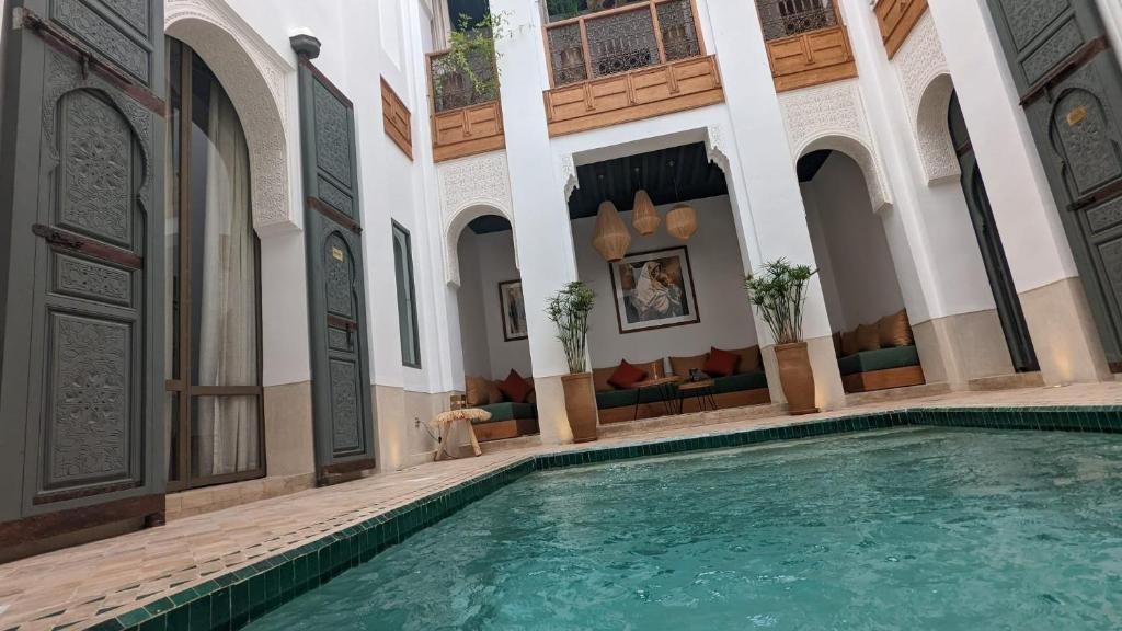 a large swimming pool in a building with a building at Riad Jardin Des Sens & Spa in Marrakesh