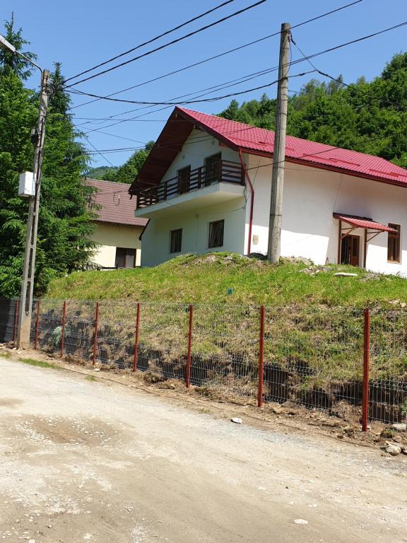 a house on top of a hill with a fence at Casa Alin Poiana Mărului in Poiana Mărului