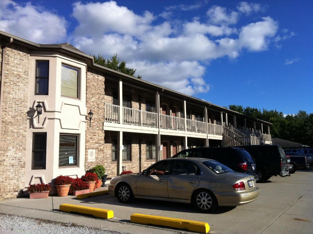 une voiture garée dans un parking en face d'un bâtiment dans l'établissement East Street Inn & Suites, à Tipton