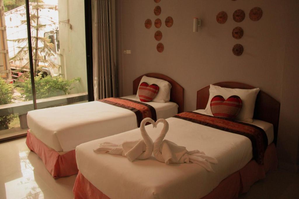 una camera con due letti con cuori sopra di Thai Lao Resort and Spa โรงแรมไทลาว รีสอร์ท แอนด์ สปา a Nakhon Phanom