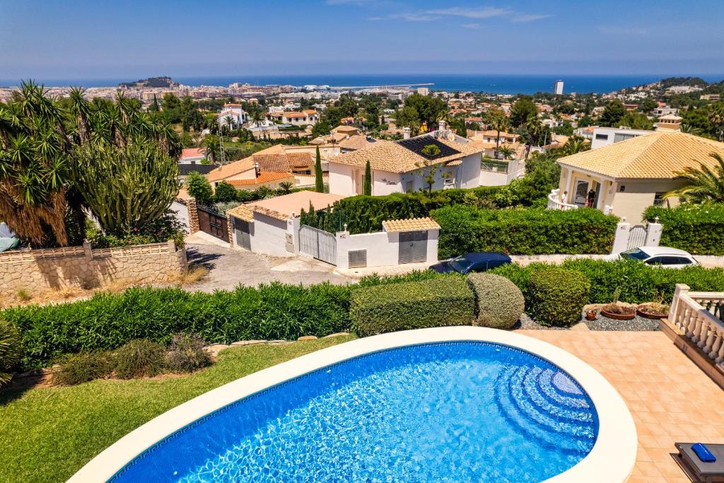 a swimming pool in a yard with a house at Villa Joli in Denia