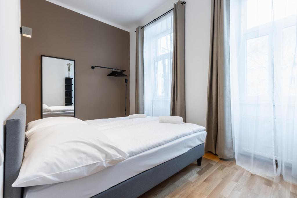 a bedroom with a white bed and a large window at Trendy apt with - smart TV, coffee machine in Meidling in Vienna