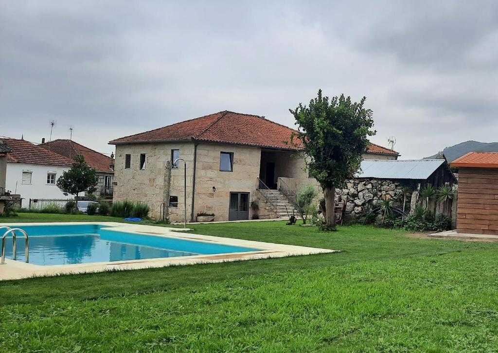 a yard with a swimming pool in front of a house at Casa da Veiga in Aldeia