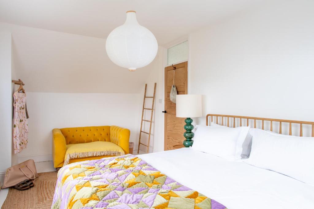 ein Schlafzimmer mit 2 Betten und einem gelben Stuhl in der Unterkunft St Ives House Lowenek in St Ives