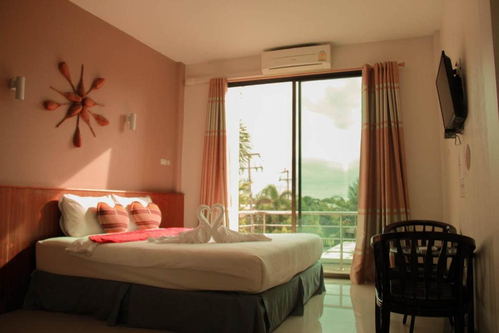 Schlafzimmer mit einem Bett und einem Fenster mit einem Balkon in der Unterkunft Thai Lao Resort and Spa โรงแรมไทลาว รีสอร์ท แอนด์ สปา in Nakhon Phanom
